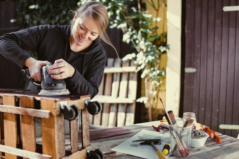 Vrouw die een zelfgemaakt rek malen openlucht bouwt van palle - upcycling