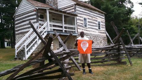 man met vlag voor wit gebouw