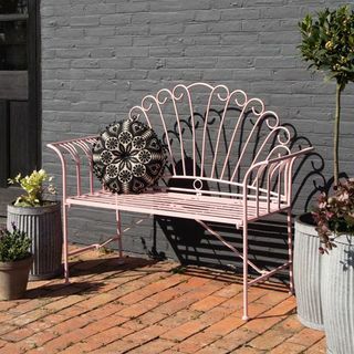 Mooie roze metalen tuinbank