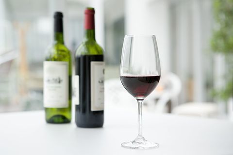 Rode wijn in glas en flessen op tafel