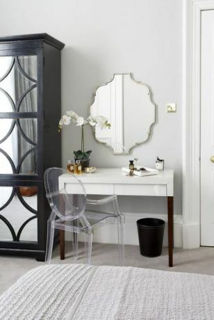 Dressoir en make-uptafel in een Victoriaans appartement met twee slaapkamers, een perspex stoel en een grote spiegel