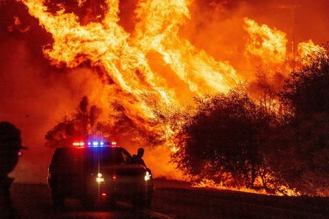 een wetshandhavingsambtenaar kijkt toe hoe de vlammen de lucht in schieten terwijl het vuur zich blijft verspreiden tijdens de berenvuur in Oroville, Californië op 9 september, Gevaarlijke droge wind in 2020 zorgde voor recordbrekende bosbranden in Californië en veroorzaakte nieuwe branden, terwijl honderden werden geëvacueerd per helikopter en tientallen duizenden werden in duisternis gedompeld door stroomuitval in het hele westen van de Verenigde Staten Foto door Josh Edelson AFP Foto door Josh Edelsonafp via Getty afbeeldingen