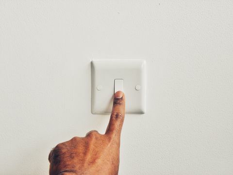 Man dringende schakelaar bord tegen muur