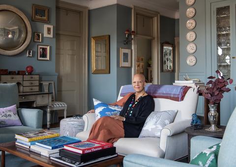 sheila bridges zittend in een woonkamer met kussens met haar harlem toile de jouy