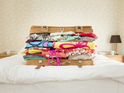 Oververpakte koffer op bed, huis in de voorsteden