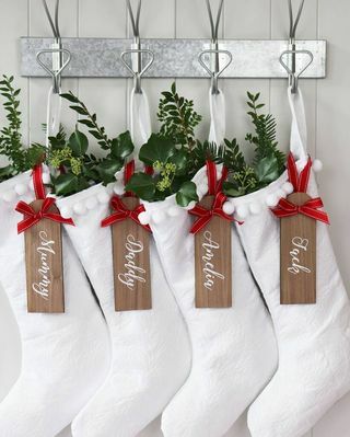 Zuiver witte kerstsok met gepersonaliseerd houten label