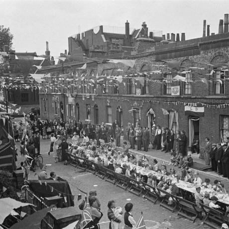 bewoners op een straatfeest in londen om de kroning van koningin elizabeth ii in 1953 te vieren