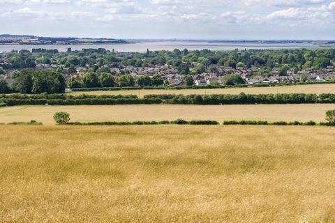 'het dorp elloughton komt uit over een tarweveld aan de oevers van de monding van de humber in yorkshire, engeland'