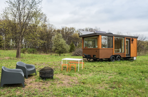 buiten het kleine glazen huis met een vuurplaats en zitplaatsen