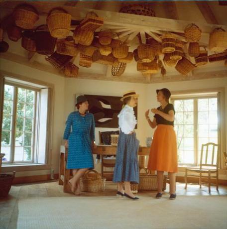 drie vrouwen in de kamer met manden aan het plafond