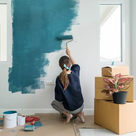 vrouw die een muur blauw schildert