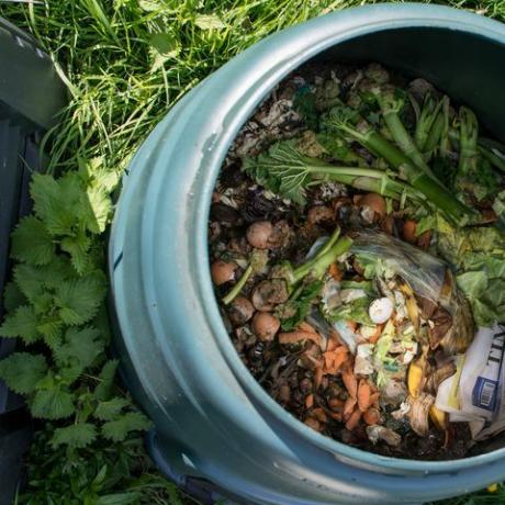 Bovenaanzicht van thuis compostbak met keukenresten en ander organisch materiaal