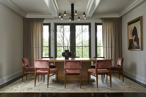 eetkamer, witte muren, bruine eettafel met rood fluwelen eetkamerstoelen