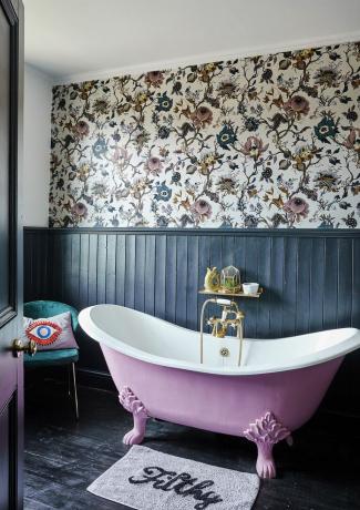 badkamer met marineblauwe panelen en roze vrijstaand bad