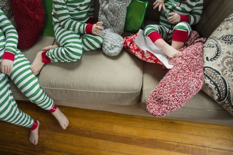 Anoniem schot van broers en zussen die kousen thuis openen op Kerstmis