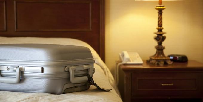 koffer op bed in hotelkamer