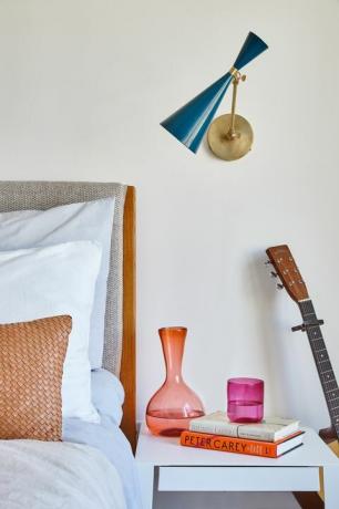 slaapkamer met bijzettafel en kleurrijke karaf