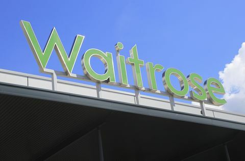 Het groene Waitrose-teken van de supermarktwinkel tegen blauwe hemel, Ipswich, Suffolk, Engeland