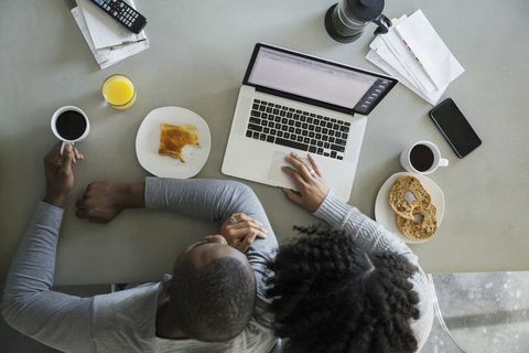 Luchtmening van paar bij laptop in keuken