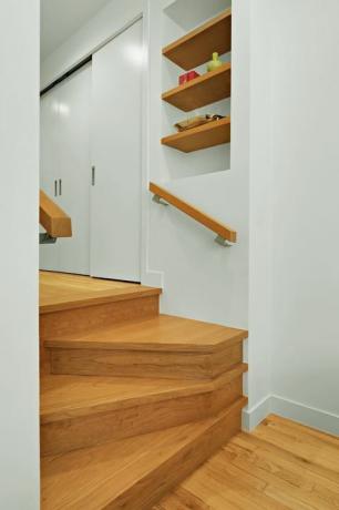 Zaktrap: op maat gemaakte moderne trap met vier treden leidt naar de hal, vormt een mini-overloop met halverwege boekenplanken.