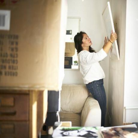Vrouw die een beeld van de muur nemen klaar in te pakken terwijl het verhuizen