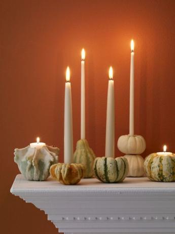 Halloween-pompoenen op mantel met kaars